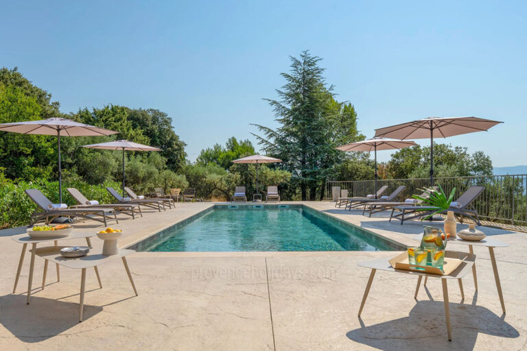 Piscine extérieure avec plages minérales, transats et vue sur la nature du Luberon